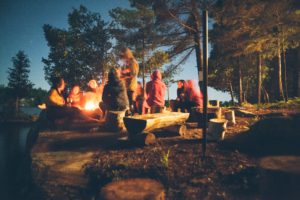Children gathered around a campfire at dusk